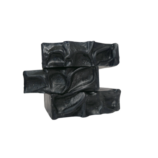 Three charcoal mint soap bars stacked on a white background