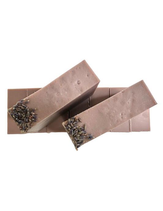 A bar of soap with natural purple color with lavender buds on top.